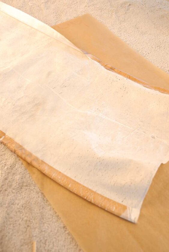 Fold down top and bottom “hems” about 1/2 inch along the long edges. Then iron (using parchment paper) to fuse hems.